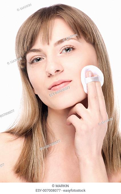 Close-up portrait of young woman with perfect health skin of face and clean sponge. Isolated on white
