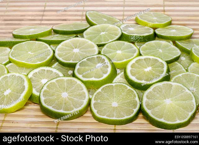 Close up view of a bunch of round slices of lime fruit isolated on a white background