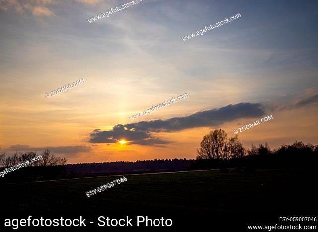 Sunset cloudy sky with picturesque clouds lit by warm sunset sunlight, colorful sunset sky with dramatic sky clouds lit by evening sunlight