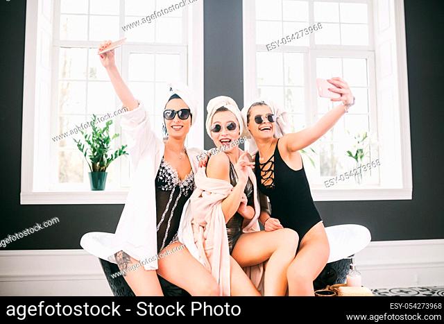 Picture showing group of happy friends in spa. girls with towels on heads having fun and taking selfie at home. Friendship, cosmetic, slumber party concept