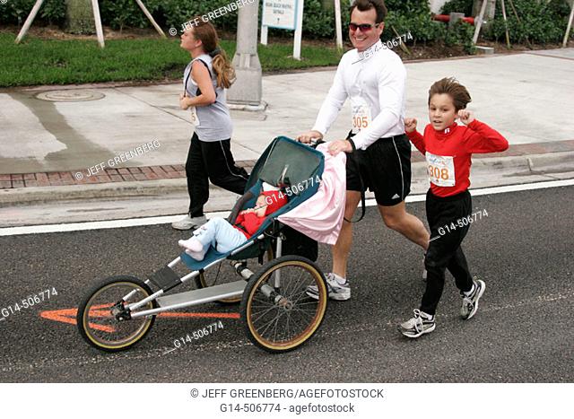 Run for the Homeless, half marathon, charity run, jog, father, stroller, baby, daughter. Miami Beach. Florida. USA