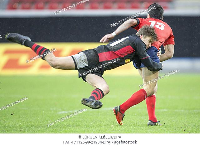 Germany's Phil Szczesny (11) holds on to Chile's Tomas Ianiszewski (15) during the rugby international match between Germany and Chile in Offenbach, Germany