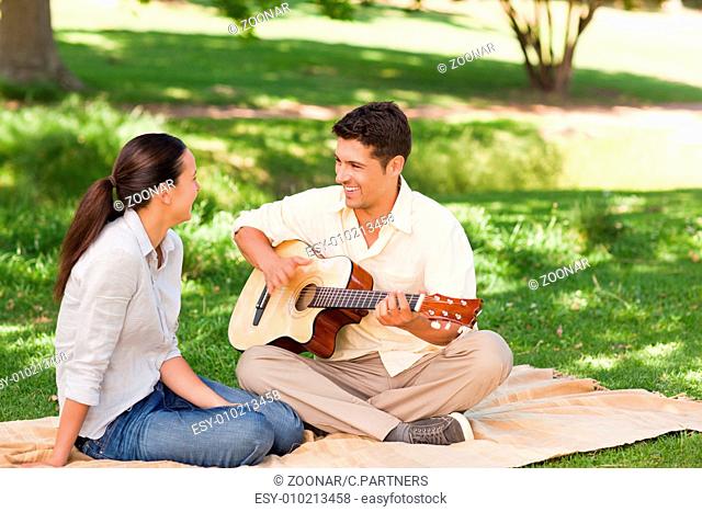 Romantic man playing guitar for his wife