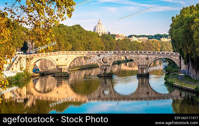 ROME, ITALY - CIRCA AUGUST 2020: Bridge on Tiber river with Vatican Basilica cupola in background and sunrise light