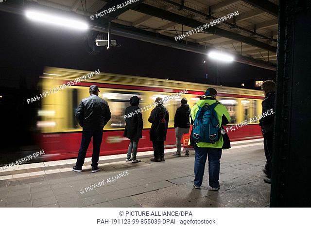23 November 2019, Berlin: Passengers stand at the Storkower Straße S-Bahn station and wait for the arriving S-Bahn. Photo: Jörg Carstensen/dpa