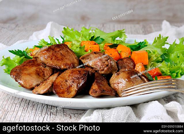 Fried chicken liver with vegetable garnish, baked pumpkin in lettuce leaves