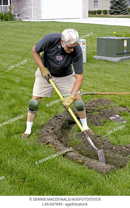 retired adult man working in second career installing lawn irrigation