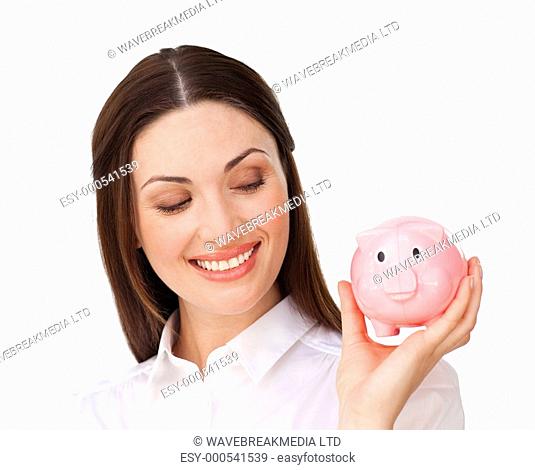 Confident businesswoman holding a piggybank isolated on a white background
