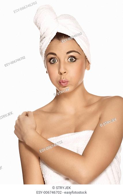 Pretty woman with a towel around her head against the white background