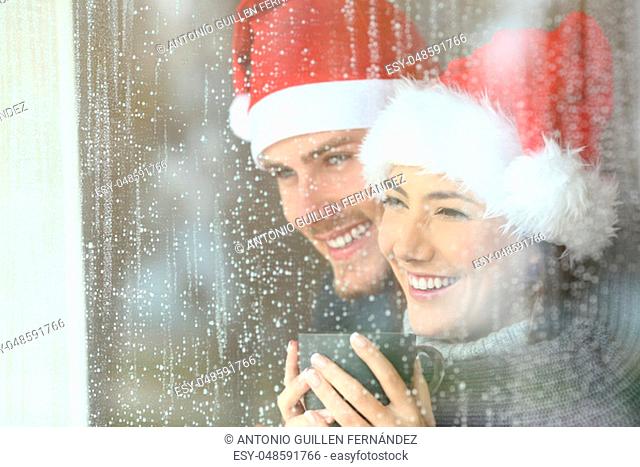 Couple looking through a window in christmas