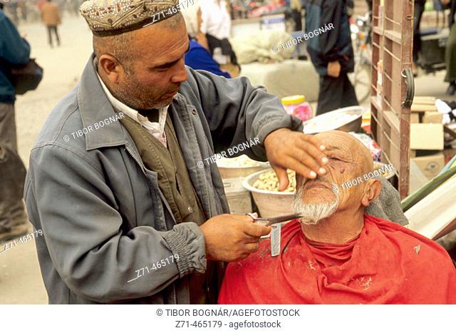 Sunday Market, barber. Kashi (Kashgar). Xinjiang. China