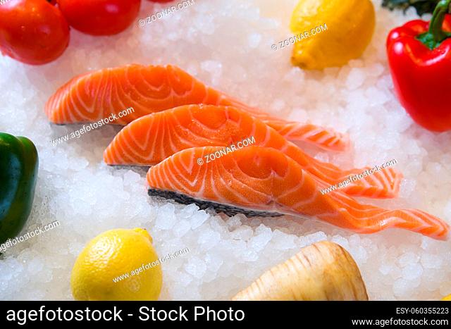 Fresh salmon fillet on ice with fruit