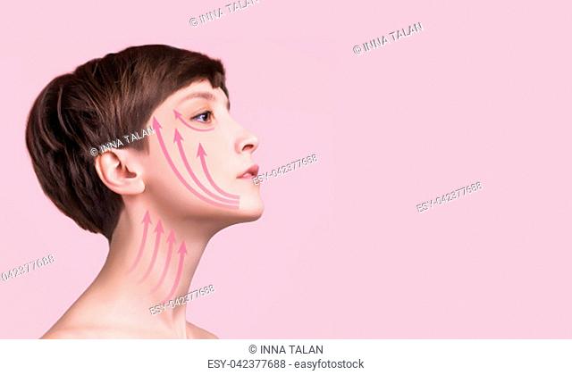Beautiful woman close up over a pastel background with arrows. Lifting and aging concept