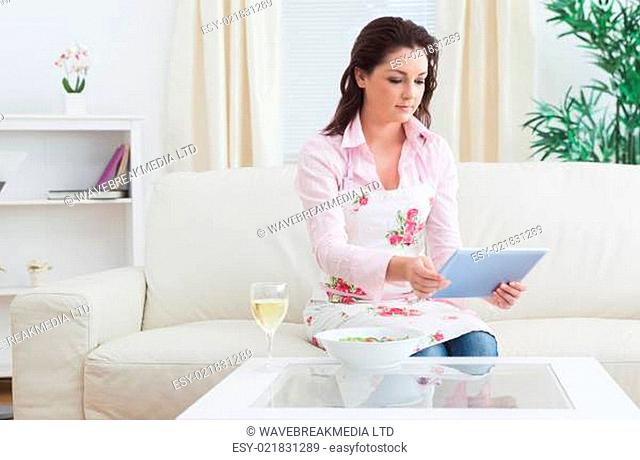 Casual young woman looking at digital tablet on sofa