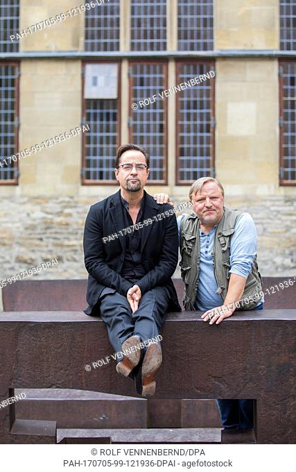 Actors Jan Josef Liefers (l) and Axel Prahl pose on two benches by artist Eduardo Chillida during the shooting of a new edition of the 'Tatort' crime series in...