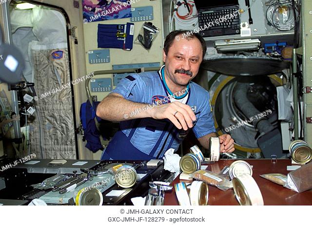 Cosmonaut Yury V. Usachev, Expedition Two commander, appears surrounded by food in the Zvezda service module aboard the International Space Station (ISS)