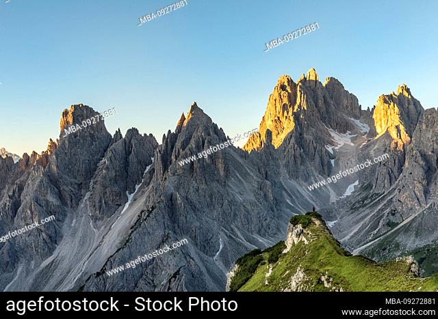 Monte Campedelle, Misurina, Auronzo di Cadore, Province of Belluno, Veneto, Italy, Europe. A mountaineer admires the sunrise in the cadini group