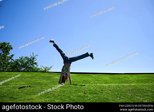 15 May 2022, Brandenburg, Potsdam: A girl beats a wheel in the sunshine at Volkspark Potsdam. Photo: Annette Riedl/dpa - ATTENTION: Only for editorial use in...