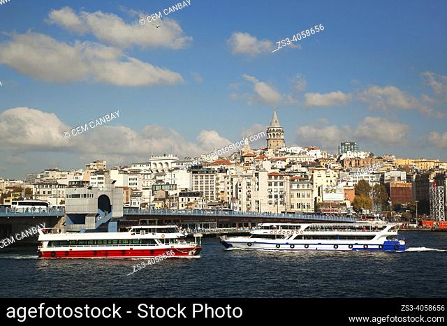 View of the Galata Tower with the Galata Bridge and the tour boats in the foreground in Galata village, a neighbourhood on the European side of the Bosphorus in...