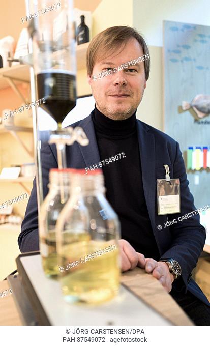 Scientist Andreas Kliemant next to a dropping funnel through which a an extract of spinach, wasabi and pepper trickles into a vessel containing rapeseed oil at...