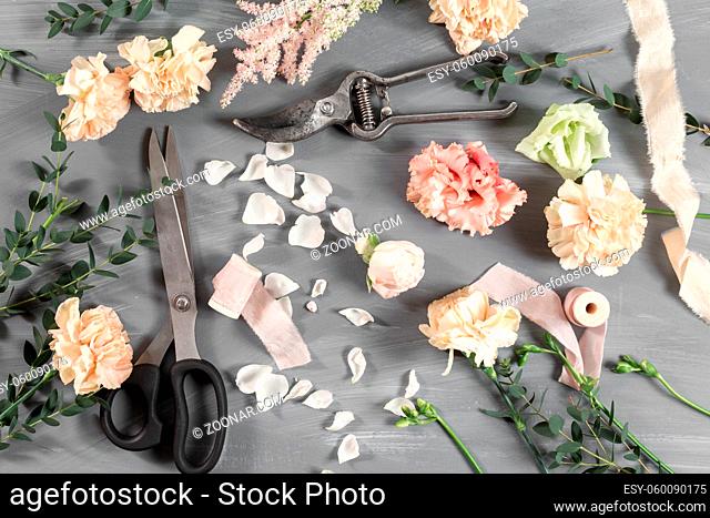 flowers and garden tools. The florist work table with accessories gray background