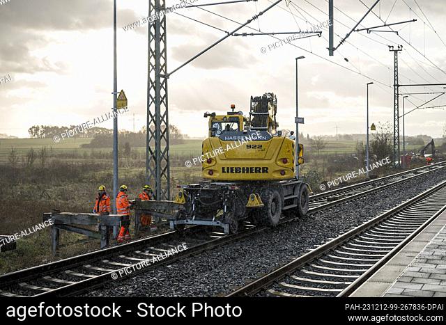 PRODUCTION - 11 December 2023, Bavaria, Eltersdorf: Workers dismantle a temporary wooden platform at the railroad construction site for the ICE line between...