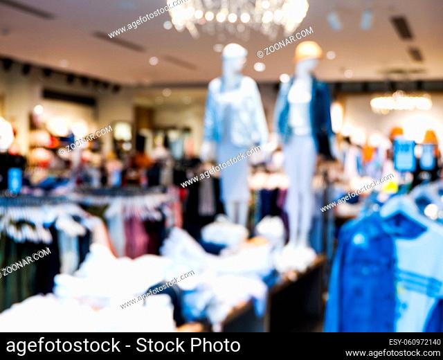 Blur image of dress store with customers and dressed mannequins