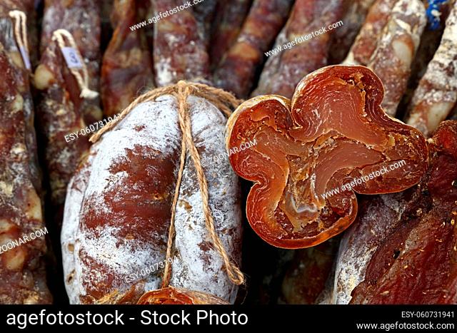 Close up selection of smoked and cured meat sausages on retail display, low angle view