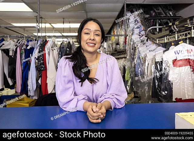 Confident Hispanic woman in her dry cleaning store