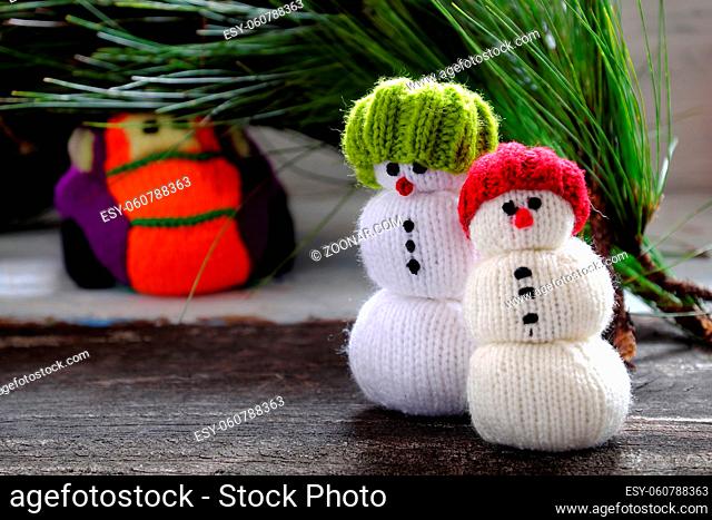 car transport pine tree for Xmas decoration, knitted colorful cars on wooden, two snowman standing beside make funny Christmas background