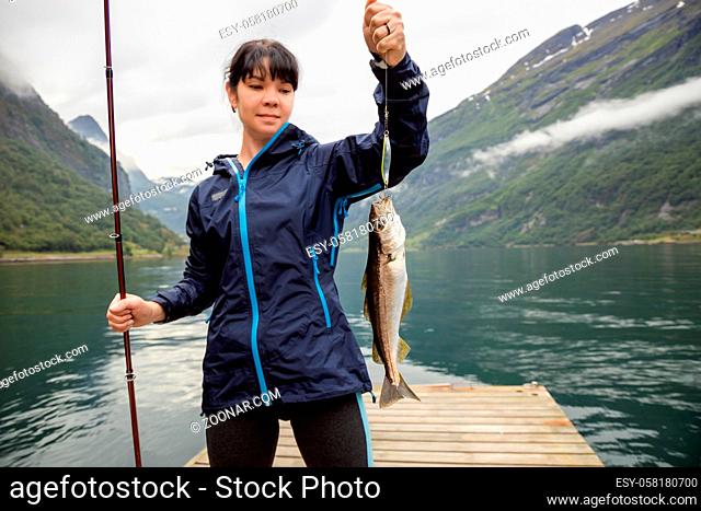 Woman fishing on Fishing rod spinning in Norway. Fishing in Norway is a way to embrace the local lifestyle. Countless lakes and rivers and an extensive...