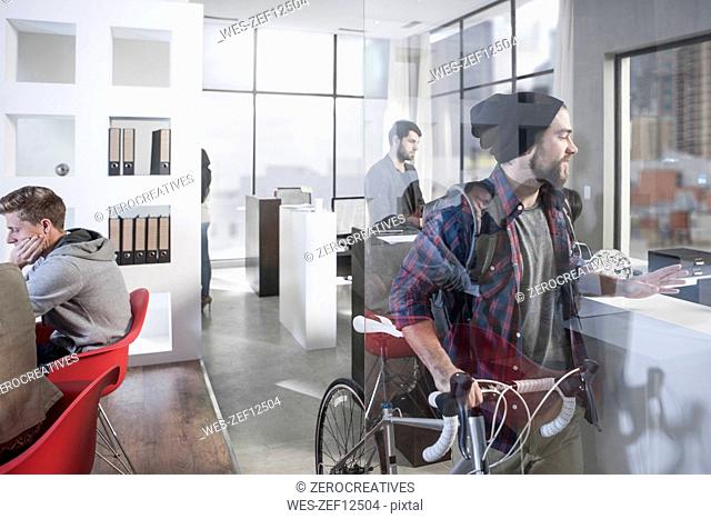 Casual man with bike in modern office