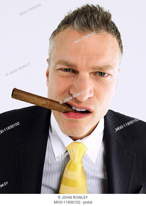 Businessman smoking cigar in studio