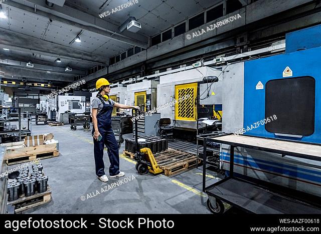Maintenance engineer standing by forklift in modern factory