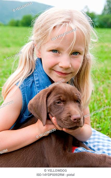 Young girl hugging her puppy