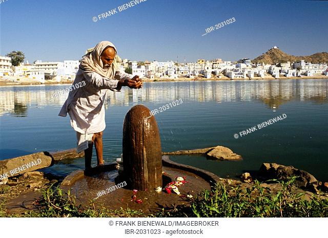 Pilgrim doing morning pooja, offering prayings to Shiva at the Lake of Brahma, Pushkar, Rajasthan, India, Asia