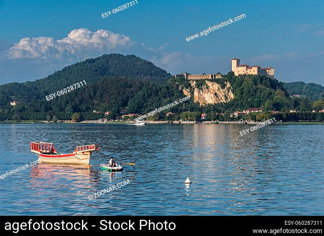 Rowing boat pulling a traditional boat on Lake Maggiore Piedmont Italy