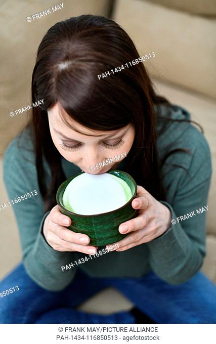 A woman is drinking matcha, powdered Japanese green tea, Germany, city of Seesen, 11. February 2019. Photo: Frank May (model released) | usage worldwide