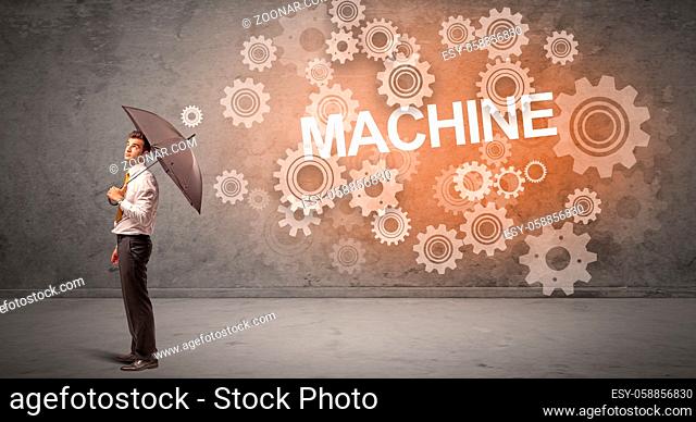 Businessman defending with umbrella from MACHINE inscription, technology concept