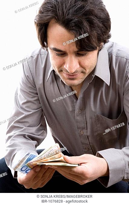 Young man counting banknotes