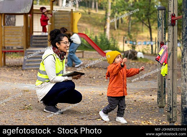 Preschool teacher with student at playground