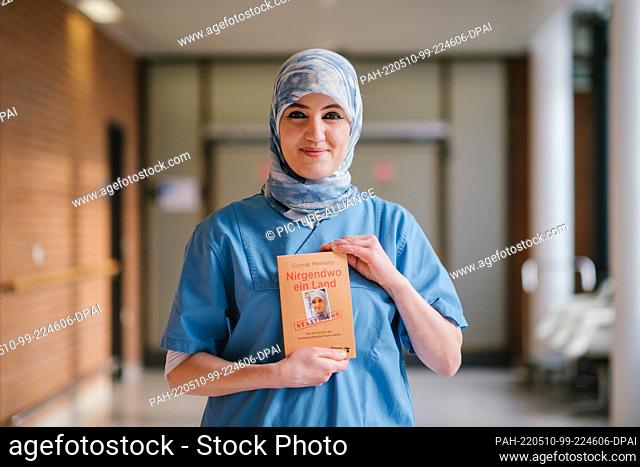 29 April 2022, Lower Saxony, Hanover: Intensive care nurse Farah Hareb-Demir holds the book ""Nowhere a Country"" in her hand on the campus of Hannover Medical...