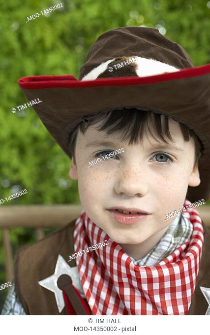 Boy 7-9 wearing cowboy costume portrait close-up