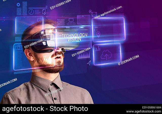 Businessman looking through Virtual Reality glasses with TECHNOLOGY VISION inscription, new technology concept