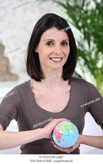 Smiling woman with globe in hands