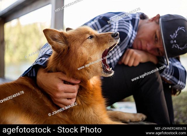 Woman looking at yawning dog