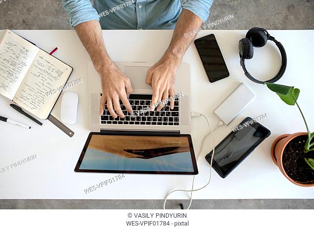Top view of man using laptop at desk in office