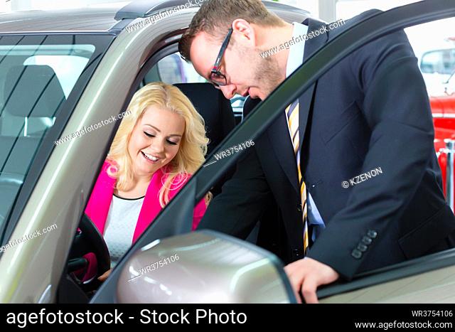 Woman buying new car in auto dealership