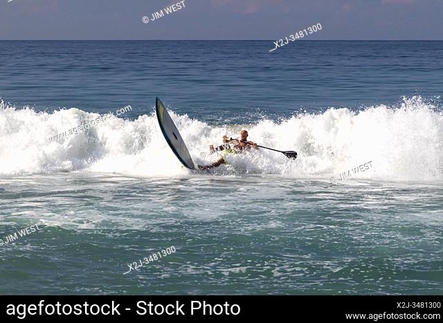 Brisas de Zicatela, Oaxaca, Mexico - A man paddles a surfboard on the Pacific Ocean