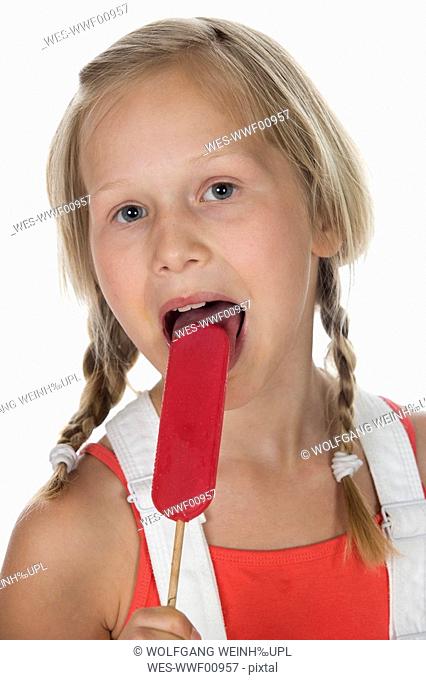 Girl 10-11 licking lollypop, portrait, close-up